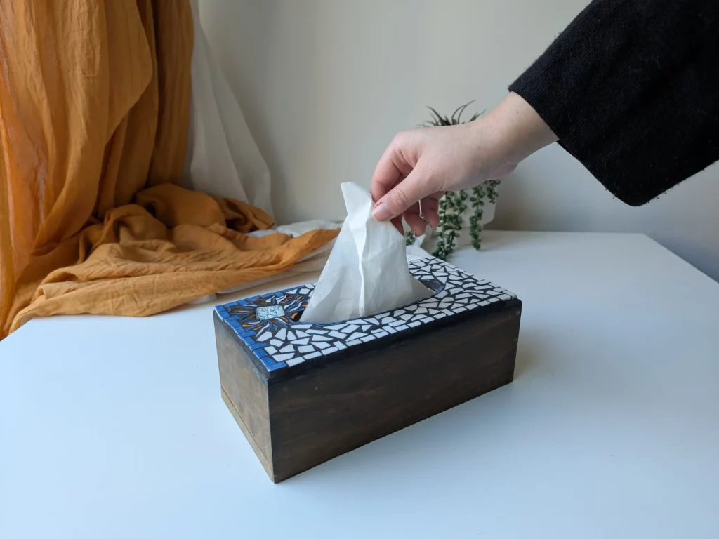 Image - Un main prend un mouchoir dans la Mosabox fleur sauvage.